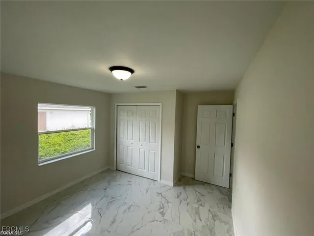 an empty room with windows and closet