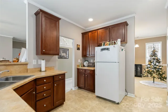 a kitchen with refrigerator a microwave a sink and cabinets