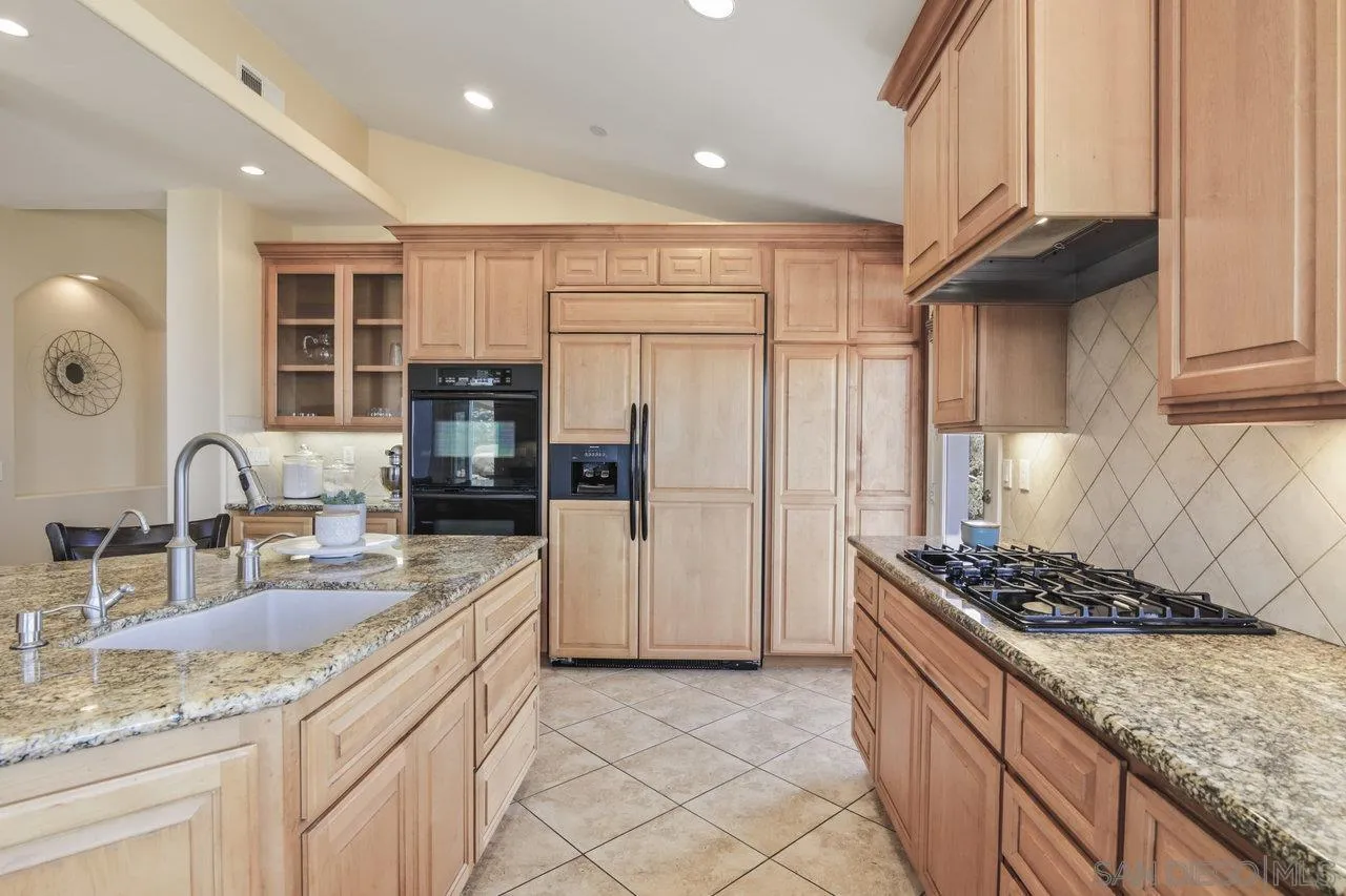 13192 Yerba Valley Way Lakeside, CA 92040 - Photo 21 of 58 a kitchen with stainless steel appliances granite countertop a sink stove and refrigerator