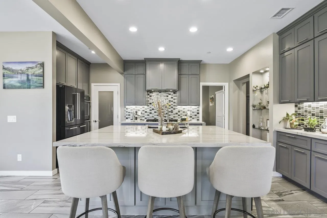 13192 Yerba Valley Way Lakeside, CA 92040 - Photo 36 of 58 a kitchen with kitchen island granite countertop a table and chairs