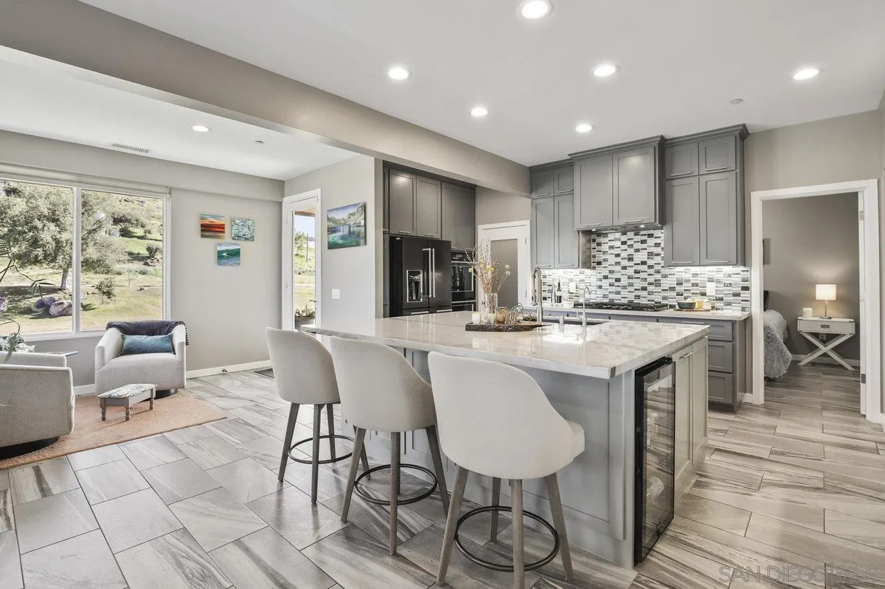 13192 Yerba Valley Way Lakeside, CA 92040 - Photo 37 of 58 a kitchen with kitchen island granite countertop a table and chairs