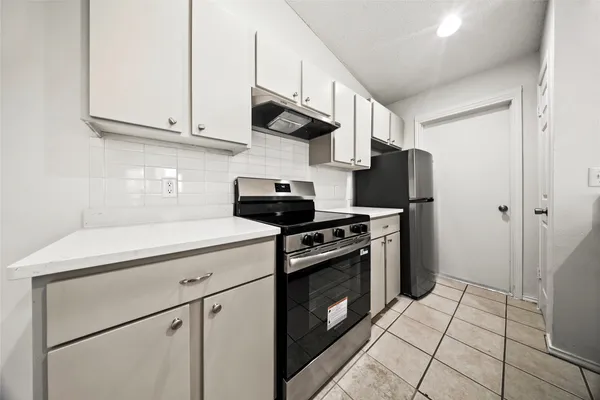 a kitchen with stainless steel appliances granite countertop a stove a refrigerator and a cabinets