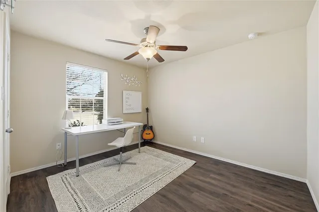 an empty room with a window and ceiling fan
