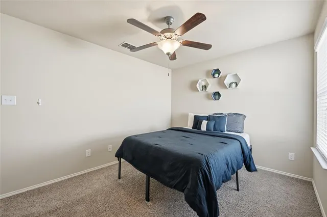 a bedroom with a bed and ceiling fan