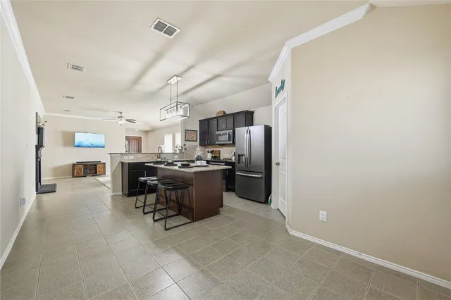 a kitchen with stainless steel appliances a refrigerator a sink dishwasher with a dining table and chairs