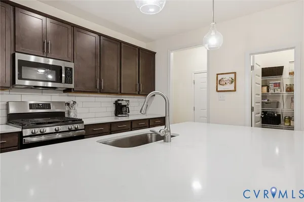 a kitchen with kitchen island a sink a stove a refrigerator and island with wooden floor