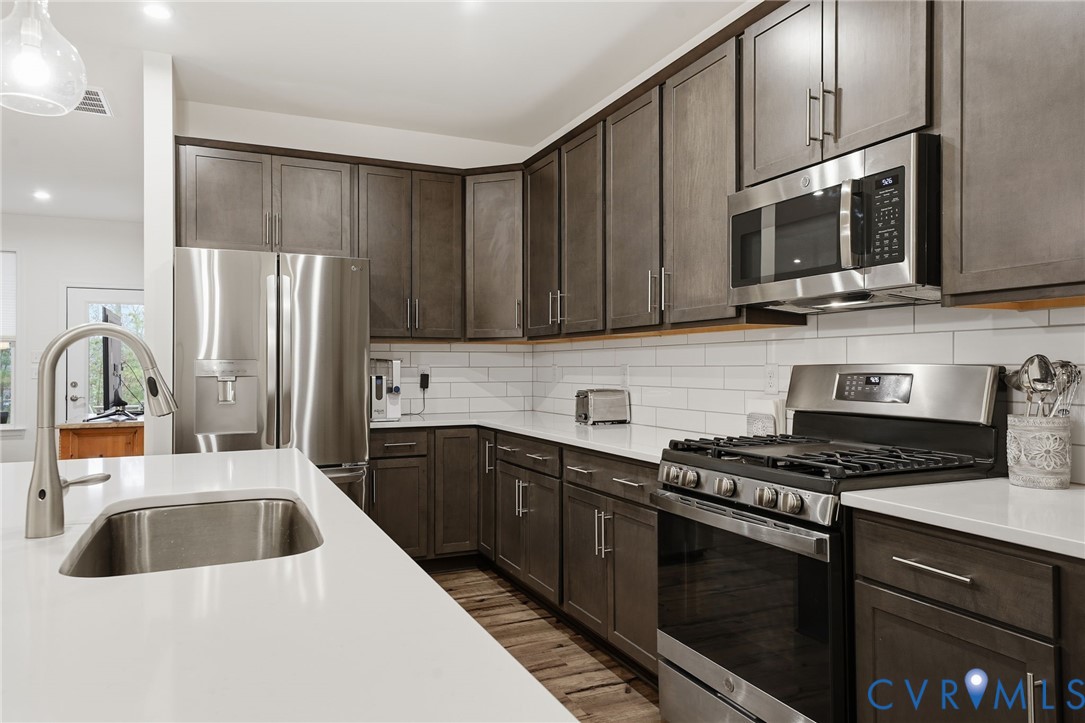 9204 Cerulean Place Richmond, VA 23238 - Photo 20 of 62 a kitchen with stainless steel appliances a sink a stove a microwave a sink a refrigerator and cabinets