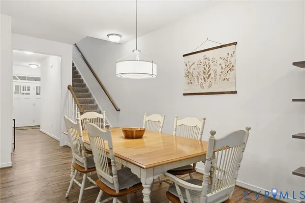 a kitchen with stainless steel appliances granite countertop a table chairs sink refrigerator and cabinets