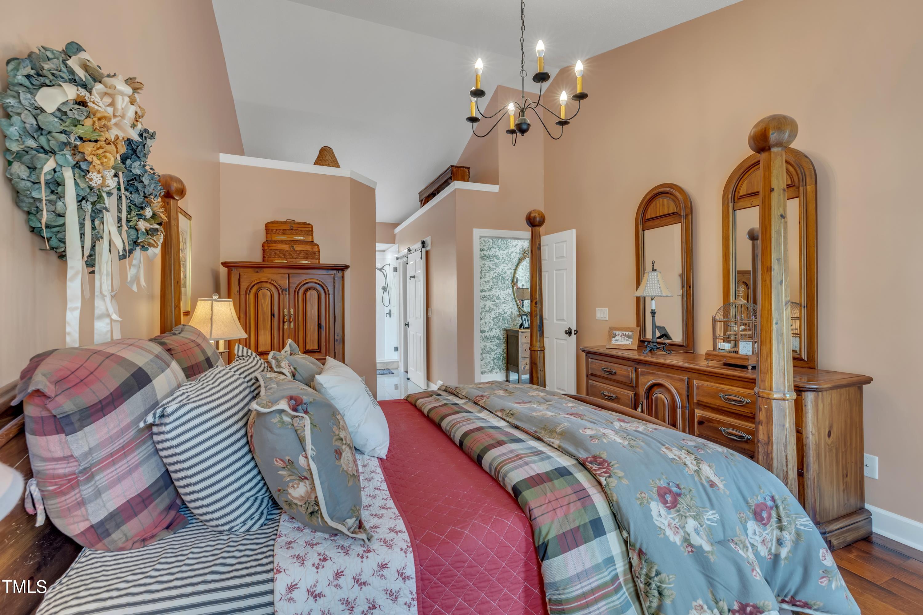 1100 Queensbury Circle Durham, NC 27713 - Photo 20 of 35 a spacious bedroom with a bed and a chandelier