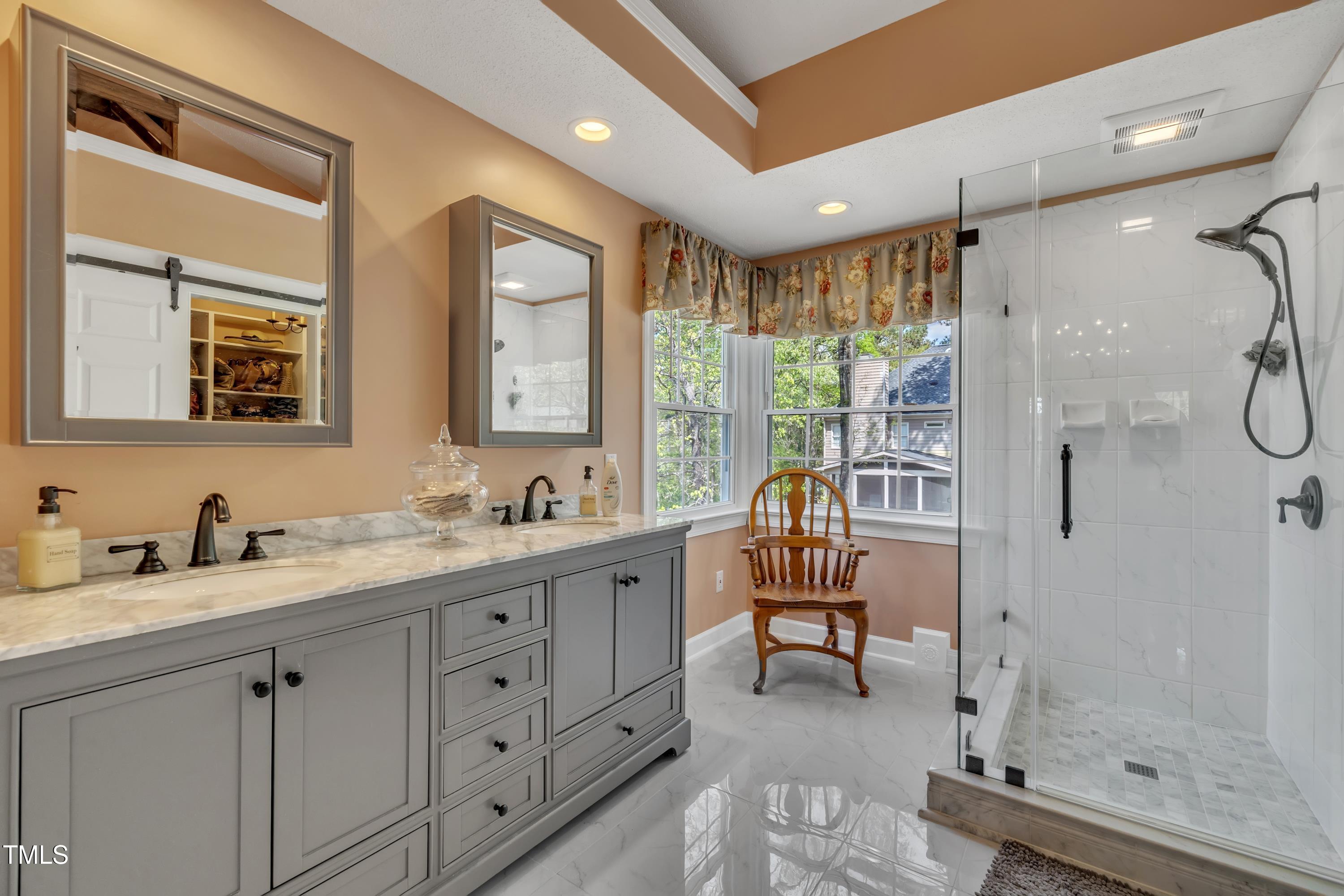 1100 Queensbury Circle Durham, NC 27713 - Photo 23 of 35 a spacious bathroom with a double vanity sink a mirror and a shower
