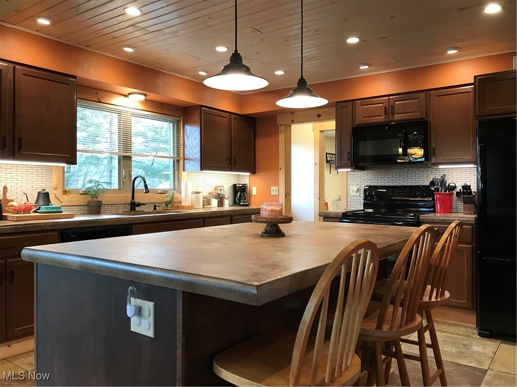 8330 Knauf Road Canfield, OH 44406 - Photo 7 of 34 Kitchen with wood ceiling, stove, a breakfast bar, fridge, and a sink