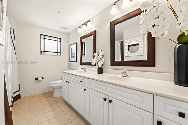 a bathroom with a double vanity sink mirror and toilet