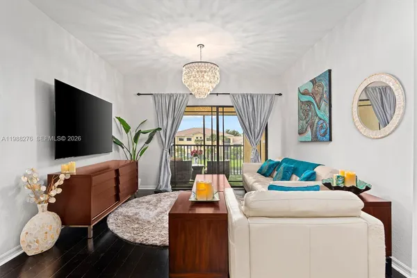 a living room with furniture a flat screen tv and a window