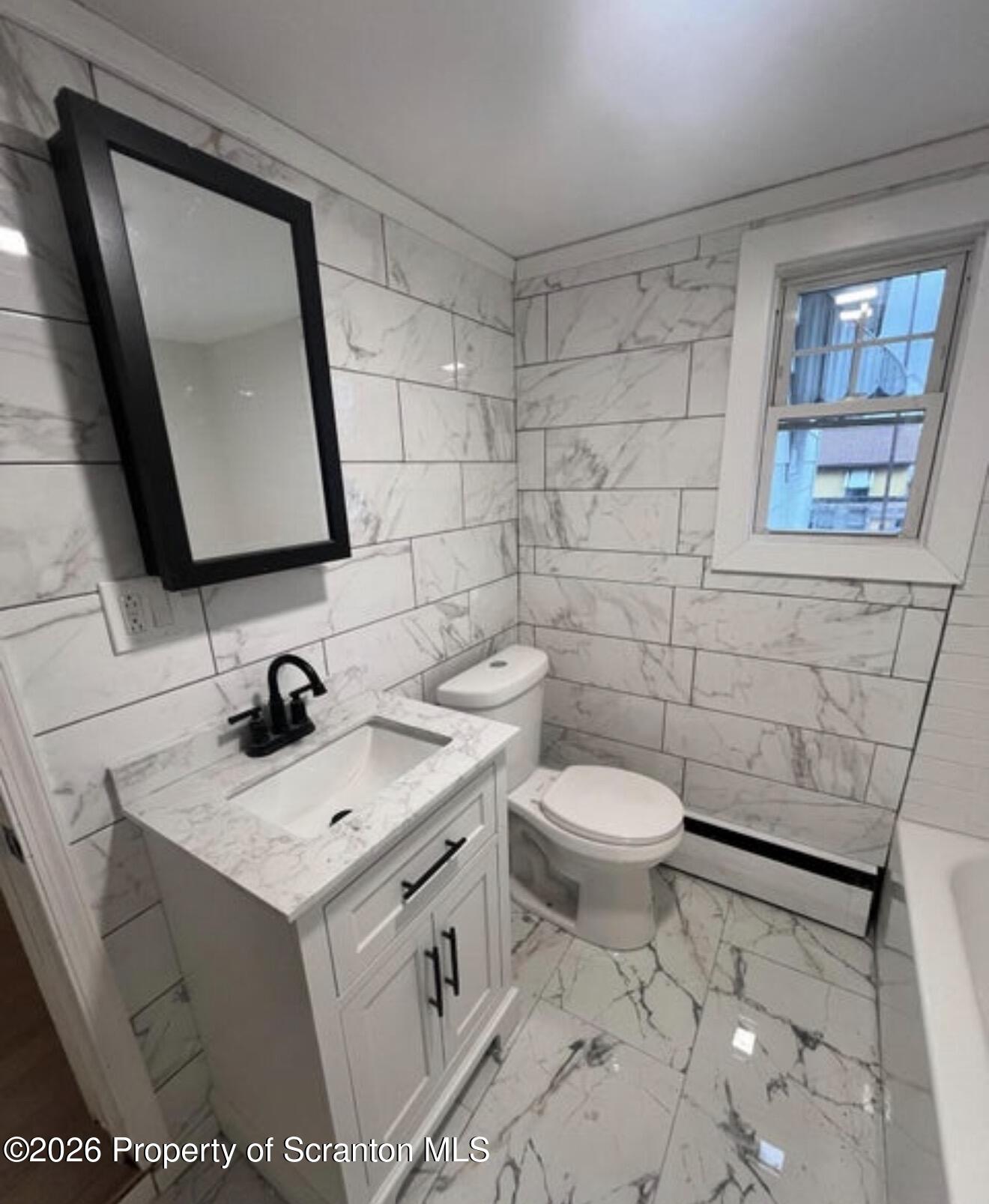 129 South Blakely Street, Unit 2 Dunmore, PA 18512 - Photo 2 of 8 a bathroom with a toilet sink and mirror