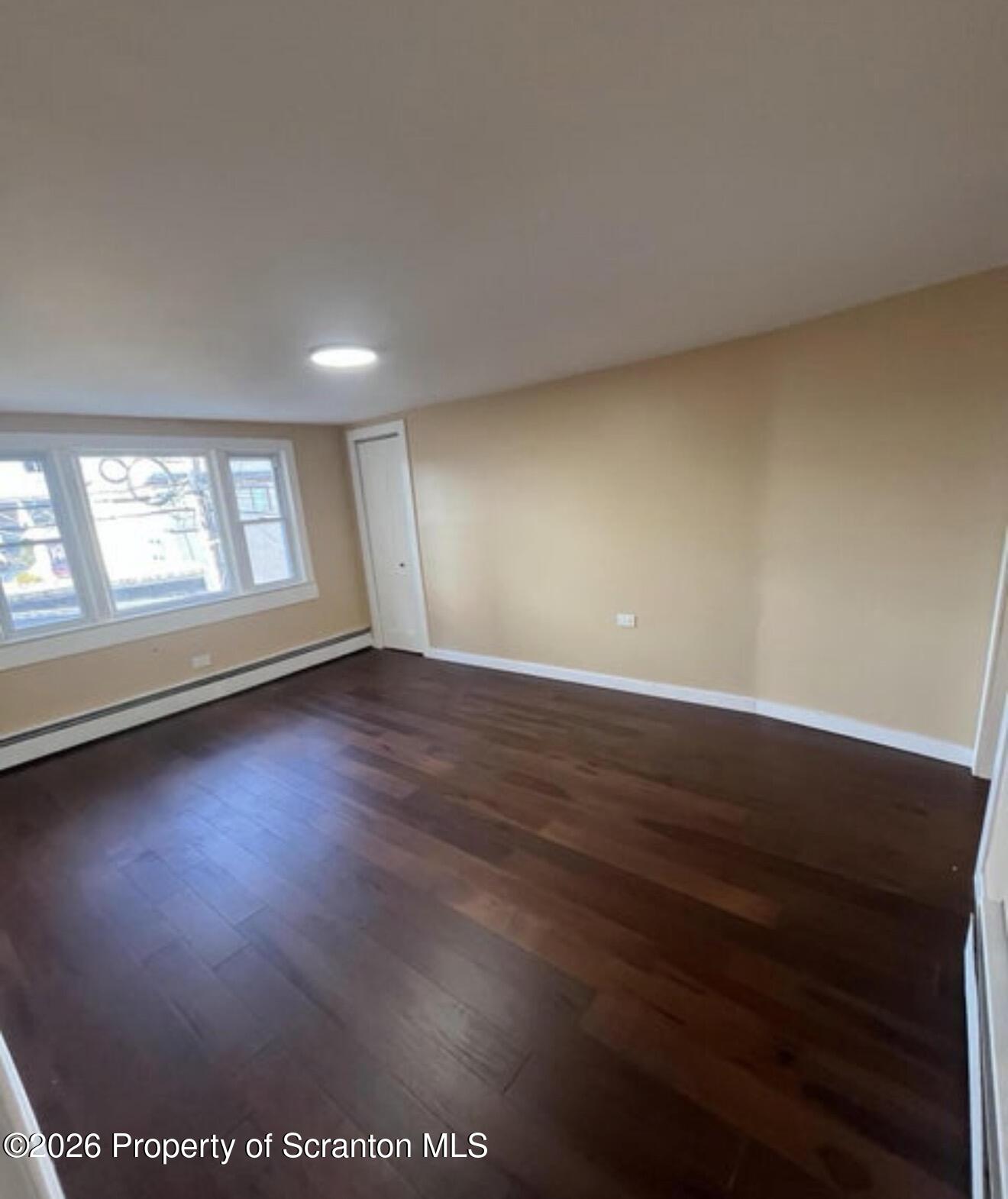 129 South Blakely Street, Unit 2 Dunmore, PA 18512 - Photo 6 of 8 an empty room with wooden floor and windows