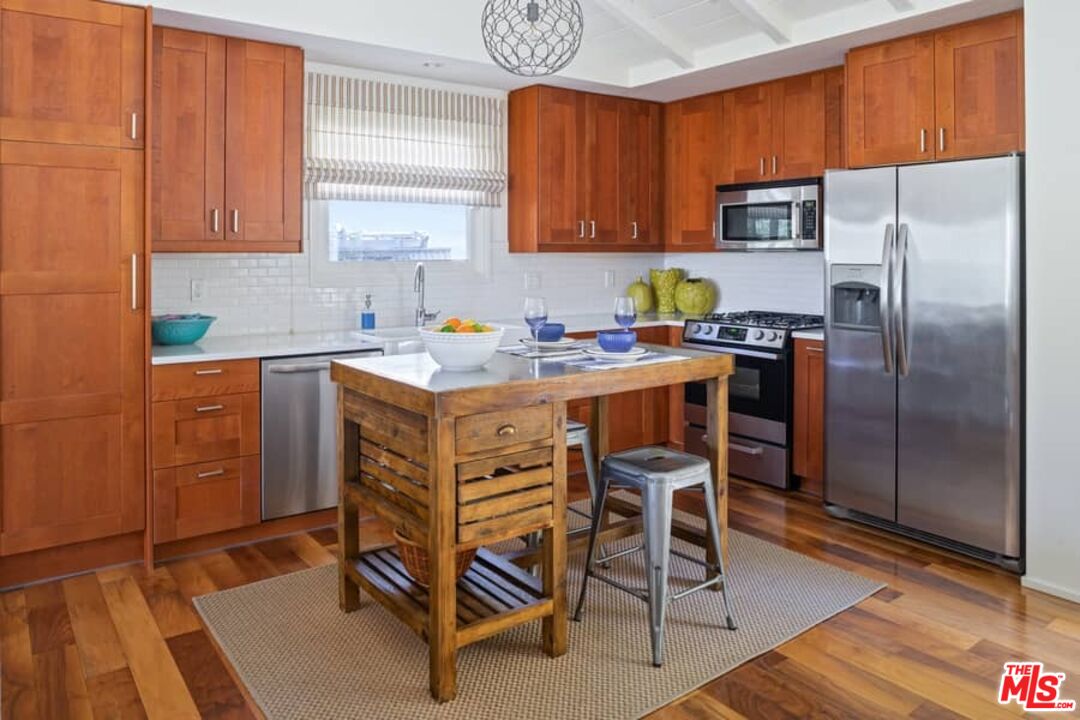 2850 Nichols Canyon Road Los Angeles, CA 90046 - Photo 12 of 38 a kitchen with a refrigerator a stove a sink and cabinets