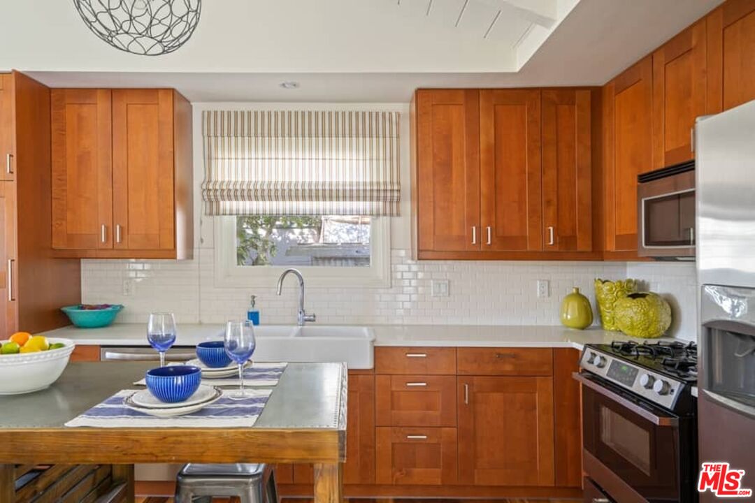 2850 Nichols Canyon Road Los Angeles, CA 90046 - Photo 13 of 38 a kitchen with stainless steel appliances wooden cabinets and a stove top oven
