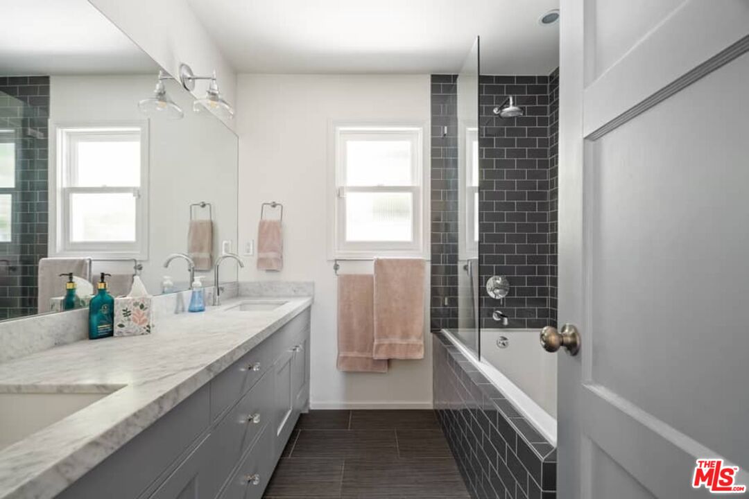 2850 Nichols Canyon Road Los Angeles, CA 90046 - Photo 18 of 38 a bathroom with a granite countertop sink mirror bathtub and shower
