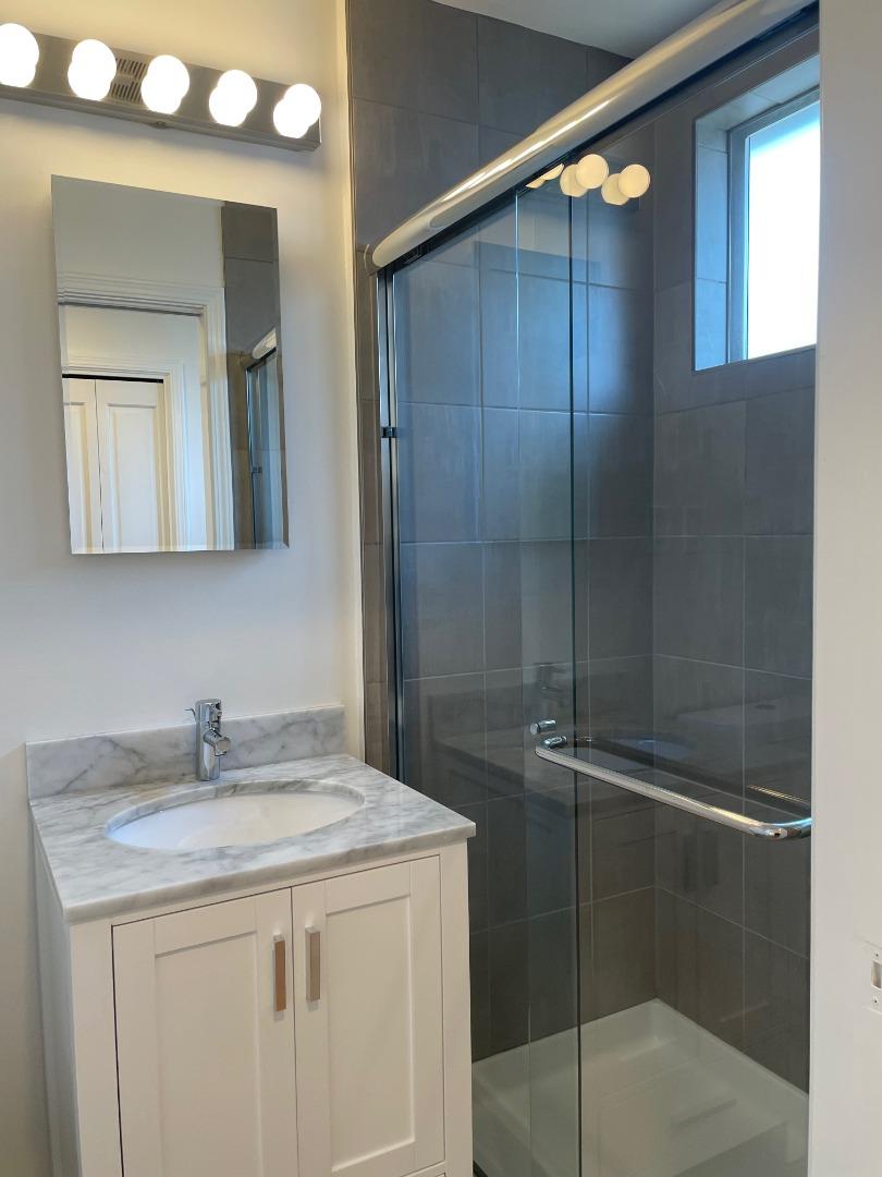 1320 Ridgewood Drive Millbrae, CA 94030 - Photo 18 of 18 a bathroom with a shower sink and mirror