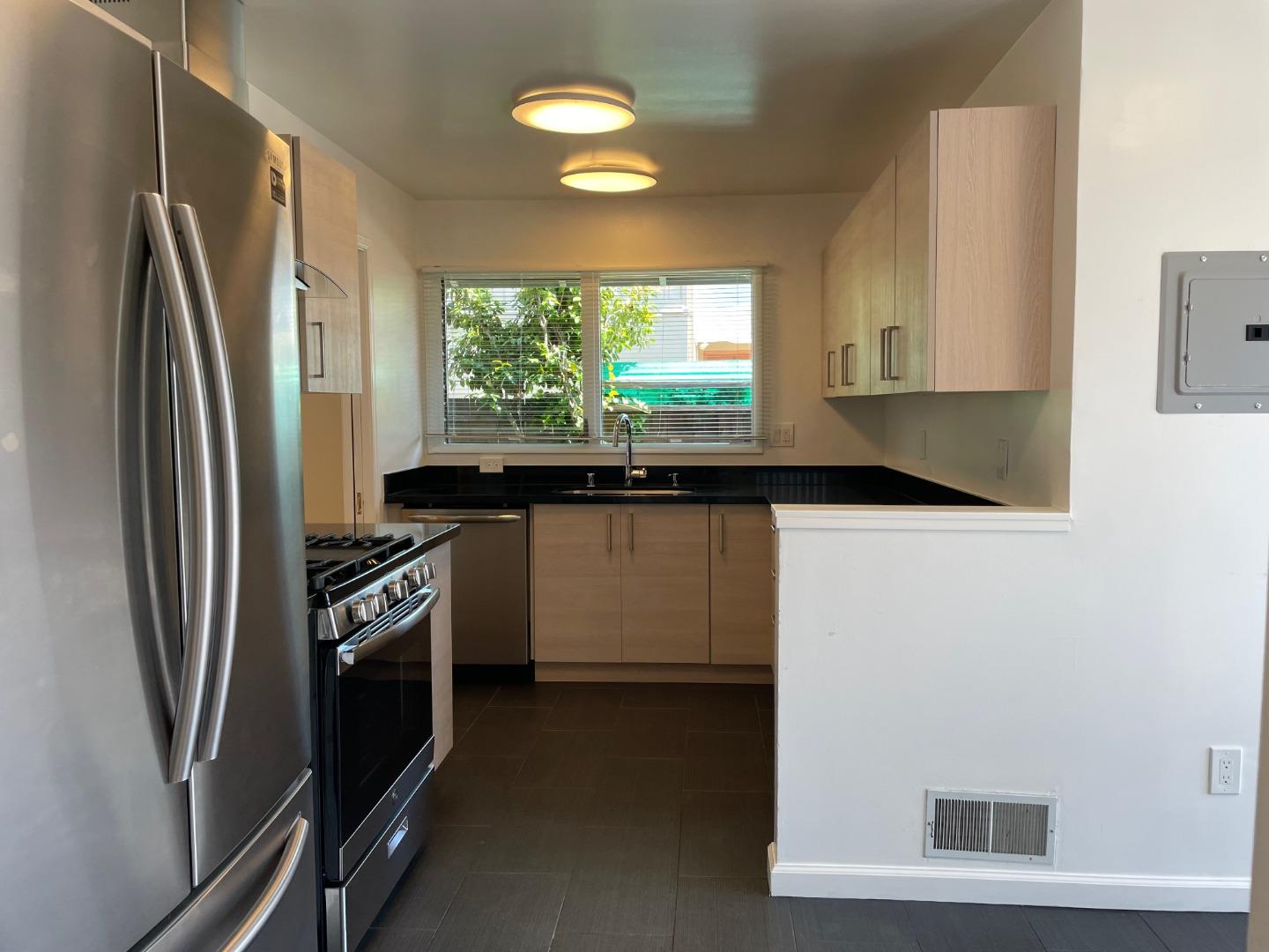 1320 Ridgewood Drive Millbrae, CA 94030 - Photo 9 of 18 a kitchen with stainless steel appliances a sink a stove a refrigerator a window and cabinets