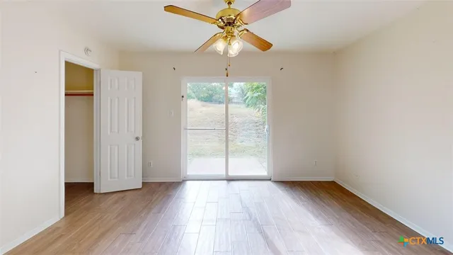 a view of a room with wooden floor fan and a window