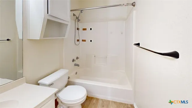 a white toilet sitting next to a bath tub