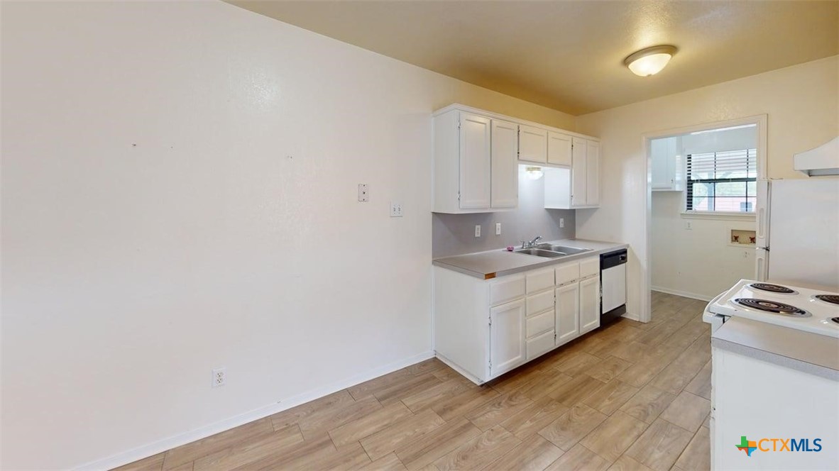 802 Hackberry Street, Unit A Copperas Cove, TX 76522 - Photo 8 of 11 a kitchen with granite countertop white cabinets and white appliances