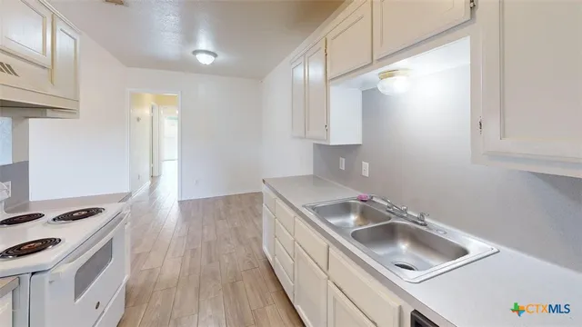 a kitchen with a sink a stove and cabinets