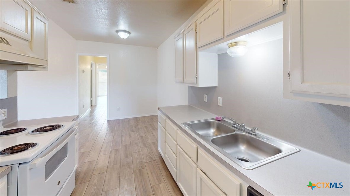 802 Hackberry Street, Unit A Copperas Cove, TX 76522 - Photo 9 of 11 a kitchen with a sink a stove and cabinets