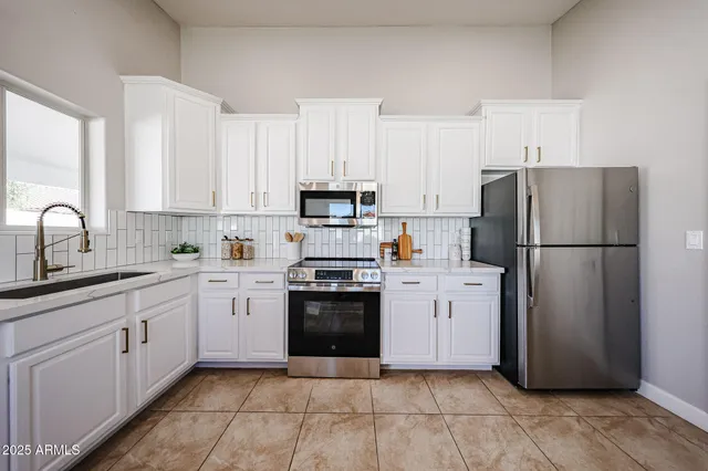 a kitchen with a refrigerator sink and cabinets