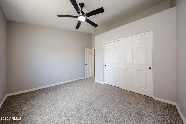 an empty room with a window and a fan