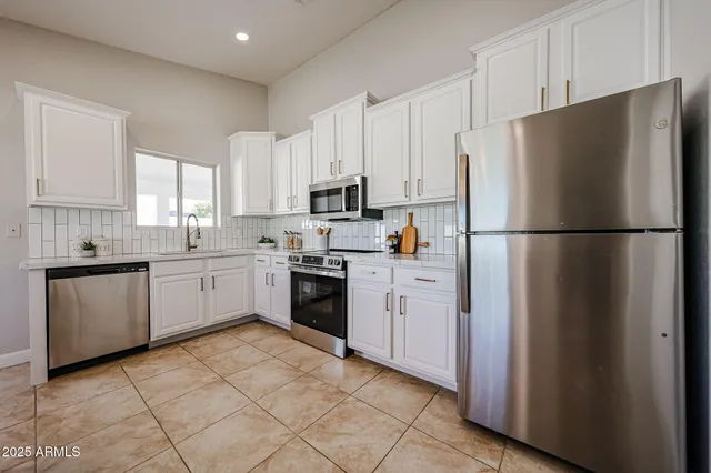 a kitchen with cabinets stainless steel appliances and window