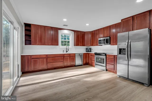 a kitchen with a refrigerator sink and cabinets