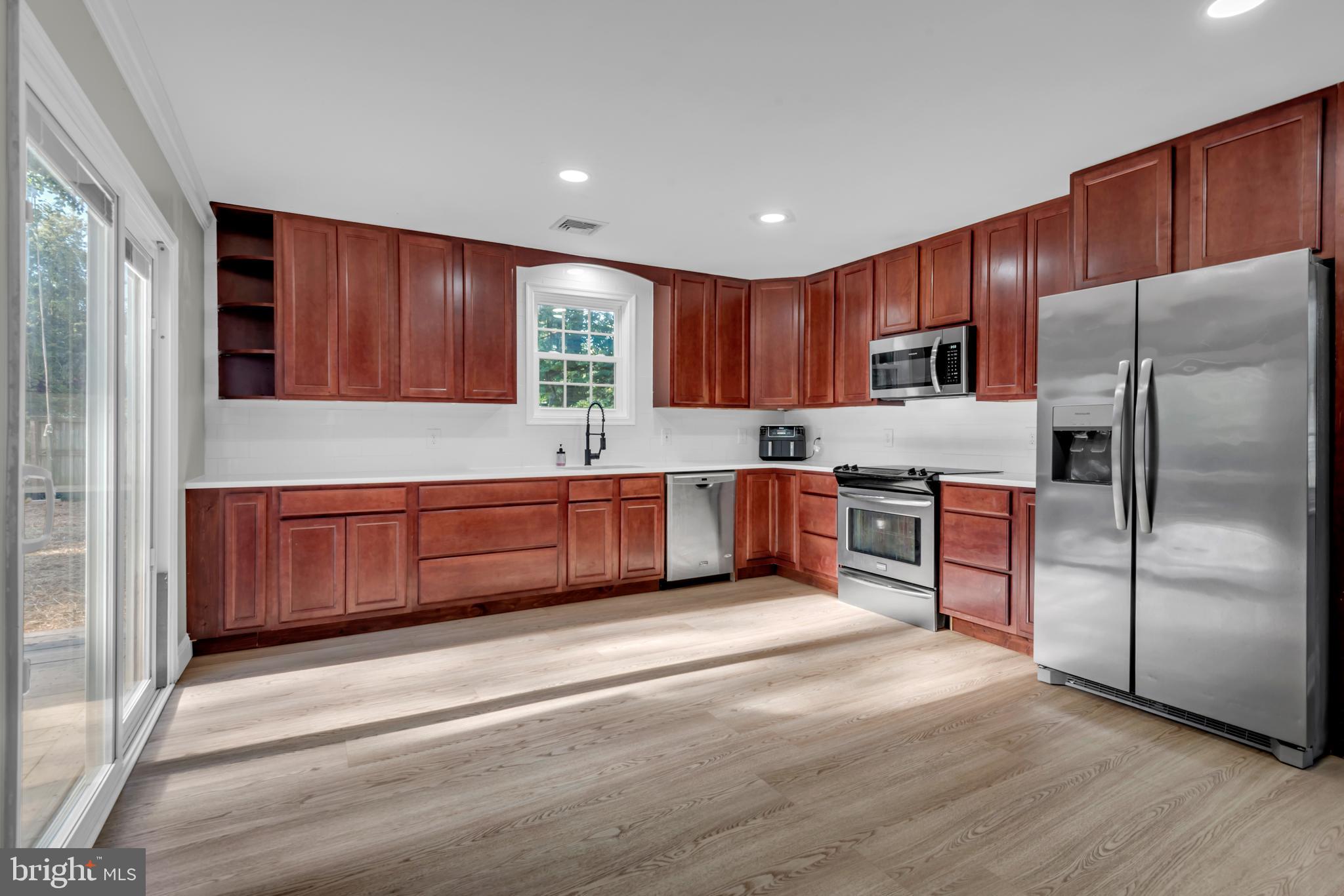 a kitchen with a refrigerator sink and cabinets