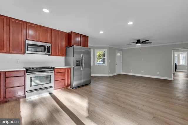 a kitchen with stainless steel appliances wooden cabinets and a stove top oven