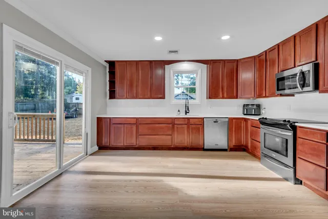 a kitchen with stainless steel appliances kitchen island granite countertop a sink and cabinets