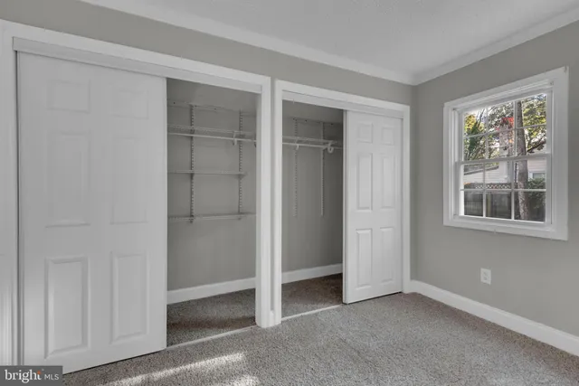 an empty room with windows and closet