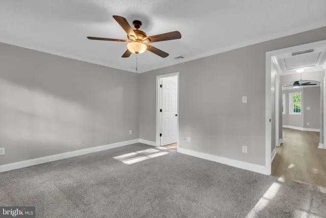 an empty room with closet and a chandelier fan