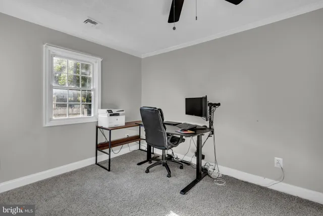 a view of a workspace with furniture and a window