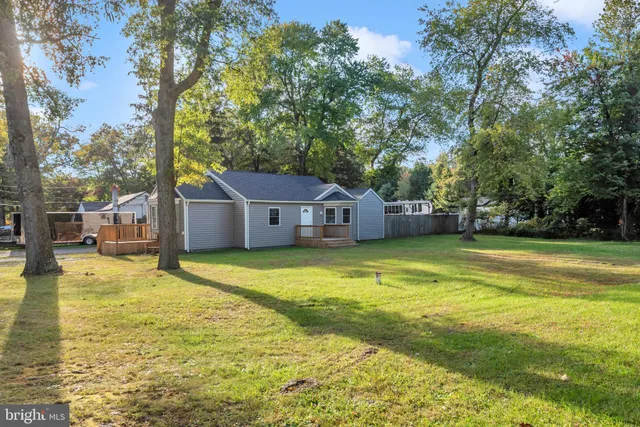 a front view of house with yard and trees in the background