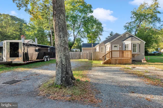 a view of a house with backyard and a tree
