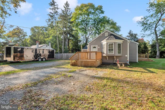 a view of a house with a yard and large trees