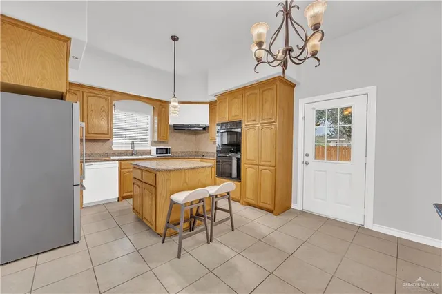 a kitchen with stainless steel appliances granite countertop a refrigerator and a stove top oven