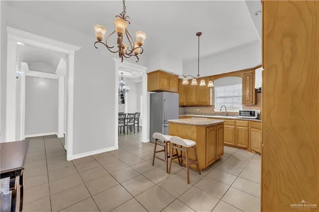a dining room with granite countertop furniture and a chandelier