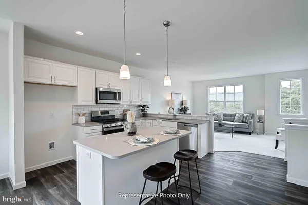 a kitchen with a sink a stove a refrigerator and white cabinets with wooden floor