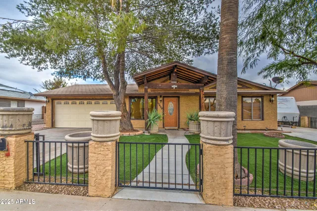 a front view of a house with a garden and trees