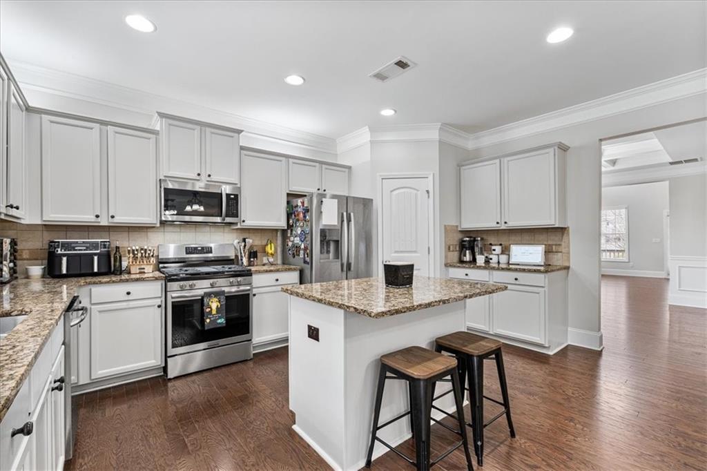 556 Olympic Way Acworth, GA 30102 - Photo 12 of 41 a large kitchen with stainless steel appliances granite countertop a stove a sink a refrigerator and white cabinets