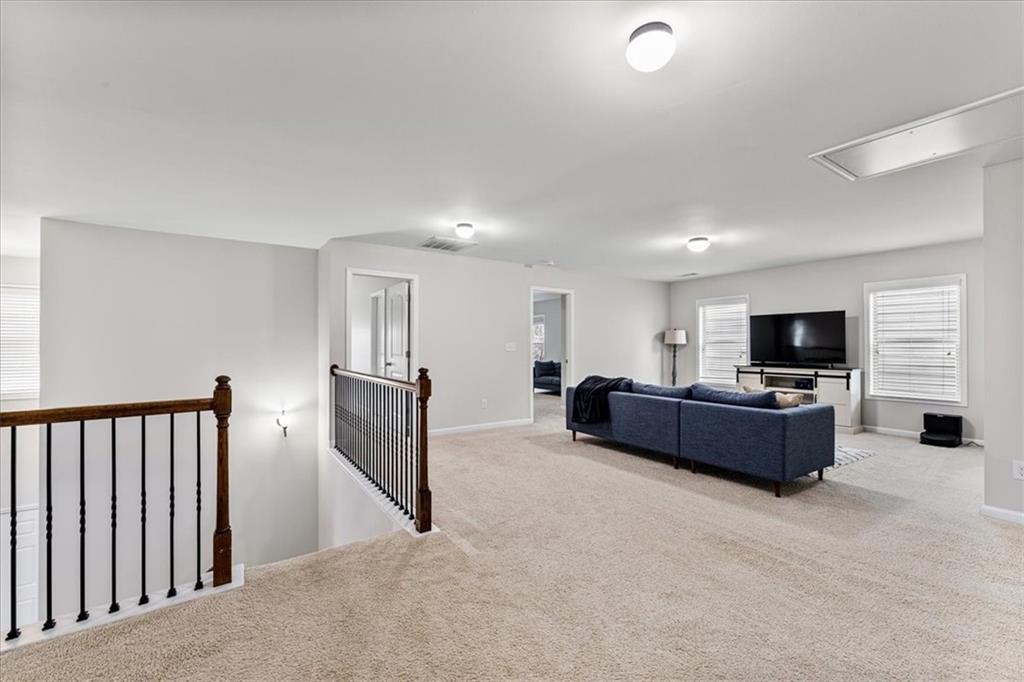 556 Olympic Way Acworth, GA 30102 - Photo 18 of 41 a living room with furniture a flat screen tv and a refrigerator