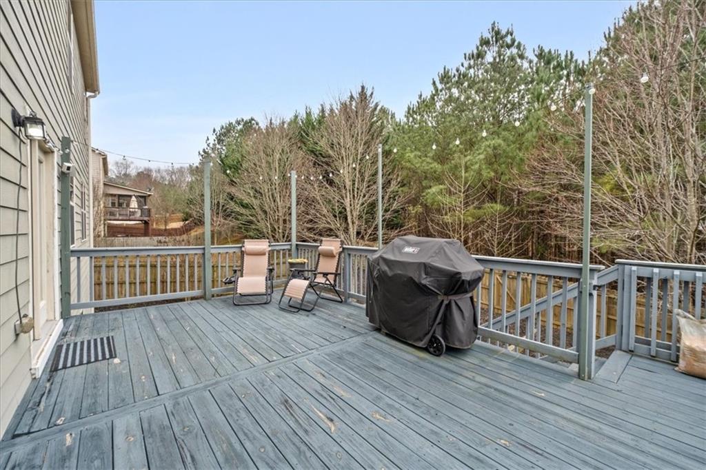 556 Olympic Way Acworth, GA 30102 - Photo 36 of 41 a view of a deck with table and chairs with wooden floor and fence
