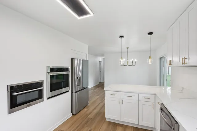 a kitchen with white cabinets and a window